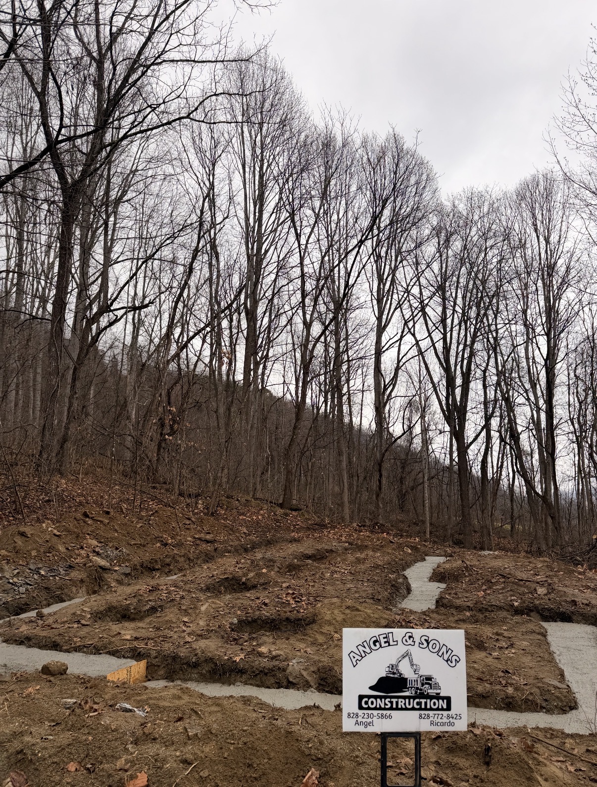Poured concrete footers on site with the Angel & Sons yard sign
