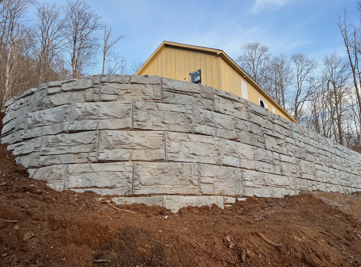 Massive curved stacked-stone retaining wall under a blue sky